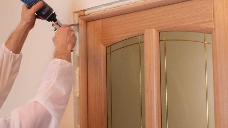 Проверка ровности дверной коробки строительным уровнем